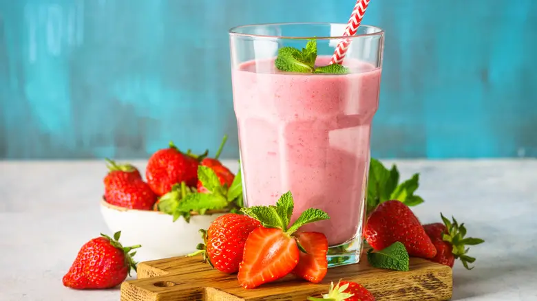 Refreshing strawberry banana smoothie in a glass with fresh fruits